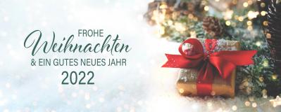 Weihnachtliche Grüße und ein gutes neues Jahr 2022. Daneben Tannenzweige und ein Geschenk