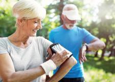 Sie hat ein Smartphone am Oberarm, er eine Armbanduhr am Handgelenk mit dem Text:"Auf die Plätze, fertig, klick!"